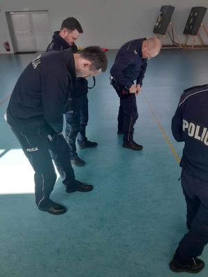Zdjęcia przedstawiają prowadzącego szkolenie z pierwszej pomocy oraz policjantów i pracowników policji w trakcie ćwiczeń