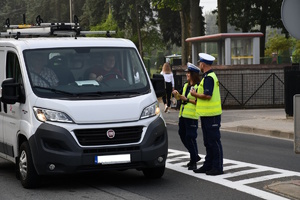 Policjanci rozdają ulotki promujące bezpieczeństwo