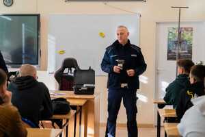 Policjant prezentuje urządzenie do sprawdzania stanu trzeźwości