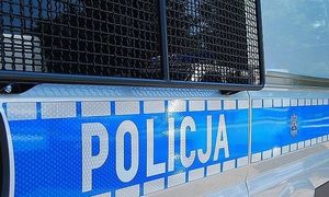 Boczne drzwi radiowozu z napisem Policja