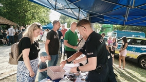 policjant rozdający malowani dla dziecka