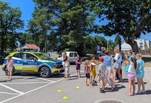 Policjant prezentuje dzieciom oznakowany radiowóz