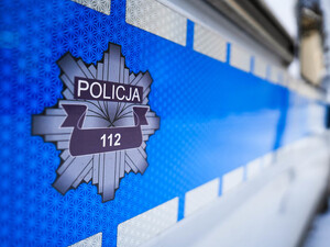 Drzwi boczne oznakowanego radiowozu z napisem policja i numerem 112