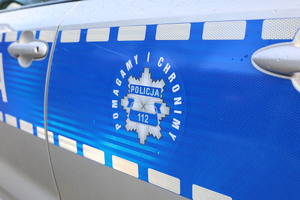 drzwi boczne oznakowanego radiowozu z napisem policja 112, pomagamy i chronimy
