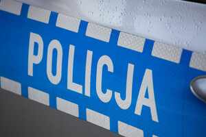 Drzwi boczne radiowozu oznakowanego z napisem policja