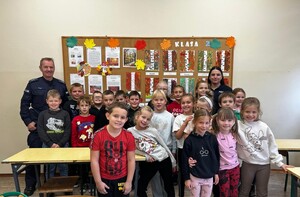 Policjanci pozują z dziećmi biorącymi udział w prelekcji