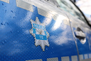 Drzwi boczne oznakowanego radiowozu z napisem Policja
