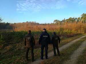 Policjant wraz ze Strażnikami Leśnymi kontrolują tereny leśne