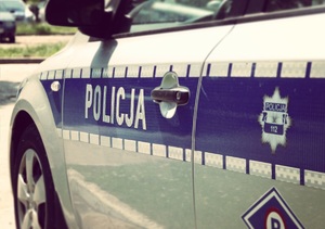 Drzwi boczne oznakowanego radiowozu z napisem policja