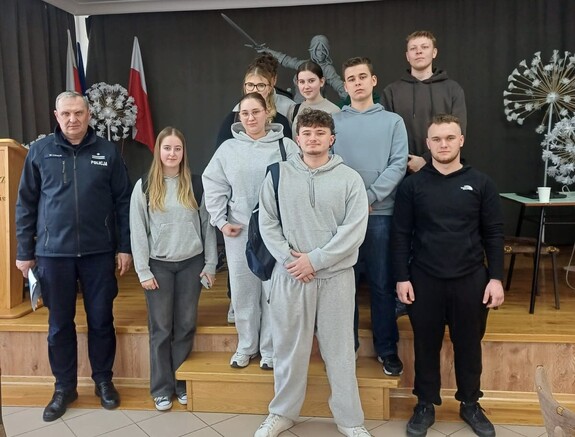 policjant z maturzystami podczas spotkania promującego zawód policjanta.jpg