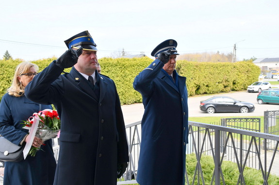 Komendant Policji i Straży Pożarnej oddają honor przed tablicą pamiatkowa