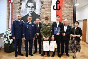 policjanci, samorządowcy i uczniowie podczas uroczystej akademii