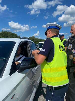 policjant rozdaje naklejki promocyjne