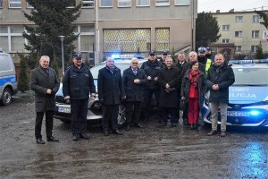 zdjęcie wszystkich współfinansujących policjantów zgodnie z tekstem na tle nowych radiowozów wraz z policjantami - zgodnie z tekstem