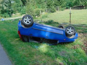 na zdjęciu niebieski pojazd po zdarzeniu drogowym, w którym dachował